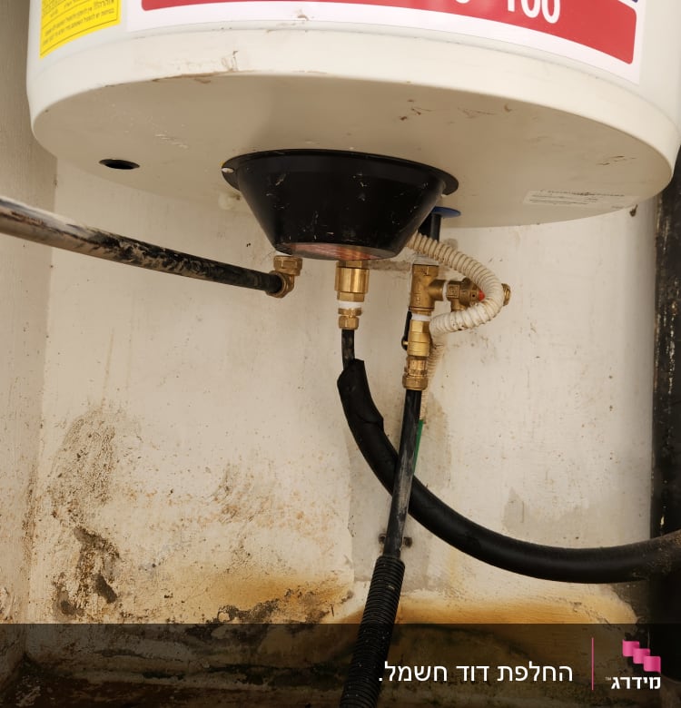 חיבורים וצינורות מתחת לדוד שמש על קיר לבן